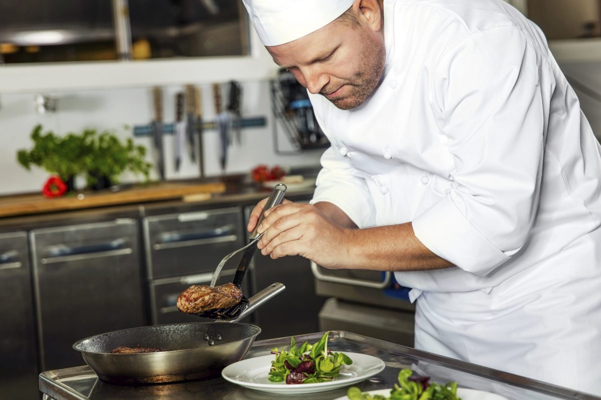 Restaurant image of chef plating. 
